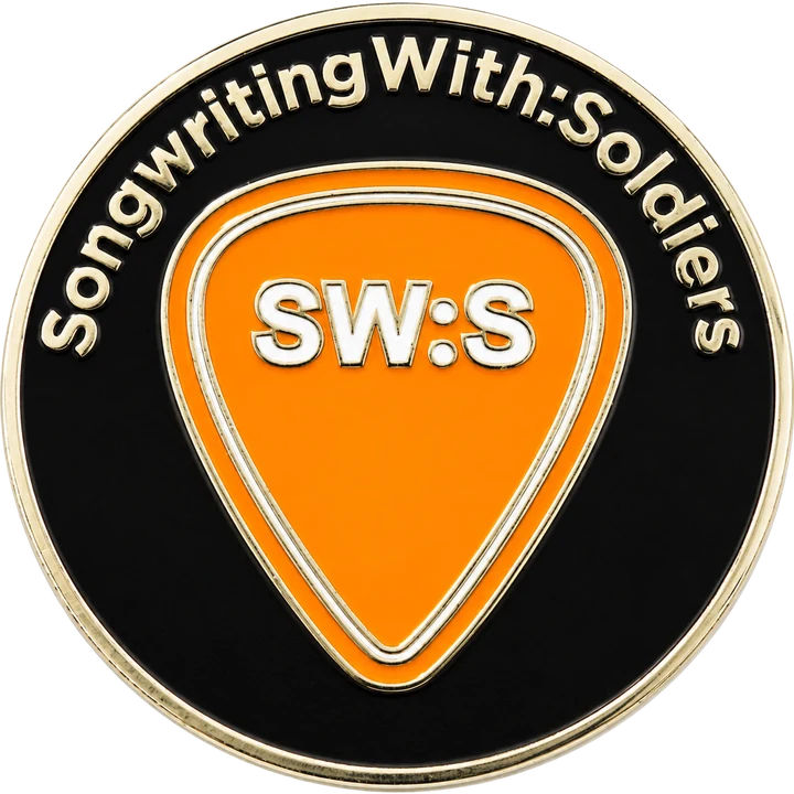 Front of the coin: Songwriting With:Soldiers around an orange guitar pick with the SW:S monogram
